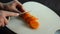 Chef cuts boiled carrots with a knife on a cutting board