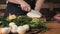 chef cuts daikon radish slices on cutting board. man cooks food in his kitchen. prepare for cooking. vegetarian.