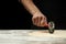 The chef cuts Italian pasta from dough. Against a dark background. A concept of preparing delicious food, Italian cuisine and