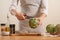 Chef cuts off artichoke petals on a light background, concept cooking tasty and healthy food, menu, recipe book, detox,