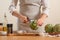 Chef cuts off artichoke petals on a light background, concept cooking tasty and healthy food, menu, recipe book, detox,