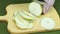 The chef cuts the pear into slices with a very sharp knife on a wooden board