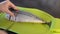Chef cuts raw headless mackerel with a knife on a cutting board