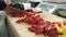 Chef cuts red pepper on cutting board in industrial kitchen