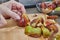 Chef is cutting Figs on wooden board in the kitchen to make pie according to the recipe from the Internet