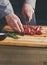 Chef cutting filet mignon on wooden board at restaurant kitchen