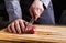 Chef cutting filet mignon on wooden board at restaurant kitchen