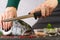 Chef cutting fresh salmon in kitchen. woman chef cuts salmon into pieces