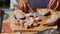 Chef cutting raw fish on a wooden chopping board