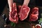 Chef cutting steak beef. Mans hands hold raw steak Tomahawk on rustic wooden cutting board on black background. Cooking