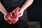 Chef cutting steak beef. Mans hands hold raw steak Tomahawk on rustic wooden cutting board on black background. Cooking