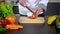 Chef cutting tomato on board in kitchen