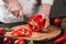 Chef cutting vegetables with knife on kitchen, cooking food. Ingredients on table.