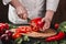 Chef cutting vegetables with knife on kitchen, cooking food. Ingredients on table.