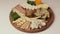 The chef decorates the cheese plate. Appetizers boards with assorted cheese, meat, grape and nuts. Speed Motion