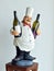 Chef doll holding bottles wine on white background