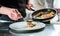 Chef finishing food on plate in restaurant kitchen