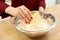 Chef with flour in bowl making batter or dough