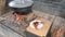 Chef with fork and plate takes out cooked ribs from a steaming pot. Cooking of traditional delicatessen for party