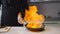 Chef frying food in flaming pan on gas hob in commercial kitchen.