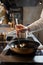 Chef frying mussels on commercial kitchen in restaurant, close-up on hands.