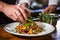 chef garnishing a farro salad with herbs