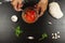Chef girl stirring tomato paste with cream, garlic and seasonings to make fresh italian pizza