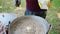 a chef with gloves adds a piece of butter to a freshly cooked porridge in a cauldron