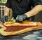 The chef grates the tenderloin of red fish, Solomon, with rosemary before grilling