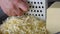 Chef grating cheese for pizza, close up