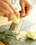 Chef grating Parmesan cheese onto a slate surface. Conceptual image