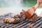 Chef grilling beef steaks on open flame BBQ.