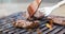 Chef grilling beef steaks on open flame BBQ.