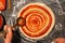 Chef hand spreading tomato paste on pizza base