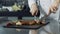 Chef hands cutting grill steak at kitchen. Closeup chef hands slicing fried meat