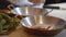 Chef hands prepare fish fillet in modern restaurant close up. Cook pouring fish filet with salted salmon and cream