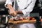 Chef hands prepare steak at kitchen. Closeup hands oil beef at planked.