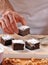 Chef hands preparing and slicing fresh brownies