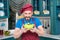 Chef in hat holds yellow plate with salad in hands and sniff. Smiling bearded man in apron and hat loves salad.