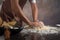 Chef hipster stylish kneads dough for bread on wooden board