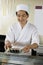 Chef Holding Plate Of Sushi In Restaurant