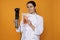 Chef holding sous vide cooker and salmon in vacuum pack on orange background