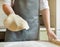 chef holds a rolled round dough in his hand