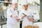 Chef instructing female trainee making eclairs