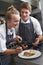 Chef Instructing Trainee In Restaurant Kitchen