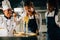 Chef instructs kids cooking noodle in kitchen. Schoolgirls in uniform create