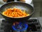chef itir fry propellers pasta with sauce pan in professional restaurant kitchen