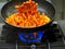 chef itir fry propellers pasta with sauce pan in professional restaurant kitchen