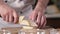 Chef in the kitchen of the restaurant cuts a ripe juicy pear with a sharp knife.