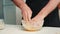 Chef kneading dough in bowl